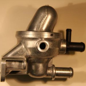 PHOTO OF ONE SIDE VIEW OF THE ORIGINAL EQUIPMENT ENGINE THERMOSTAT ASSEMBLY